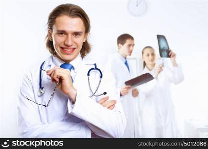 Young confident and friendly doctor in medical office