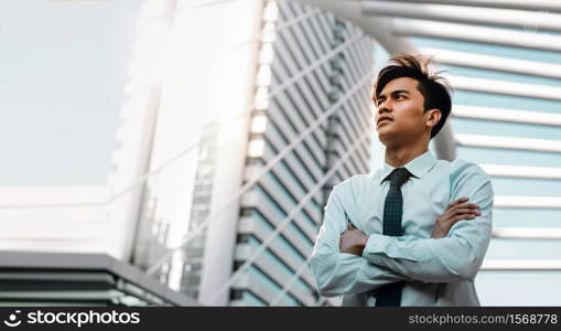 Young Confident Businessman Standing in the Urban City. Crossed Arms and Looking up into the Sky