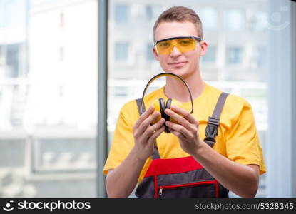 Young construction worker in yellow coveralls