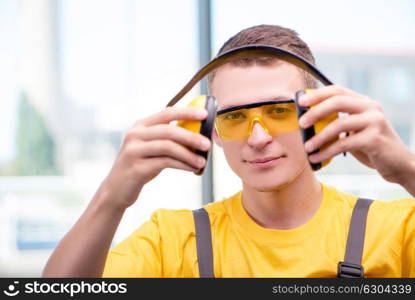 Young construction worker in yellow coveralls