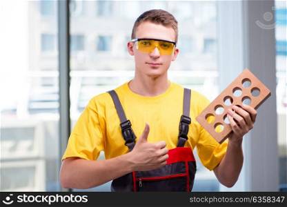 Young construction worker in yellow coveralls