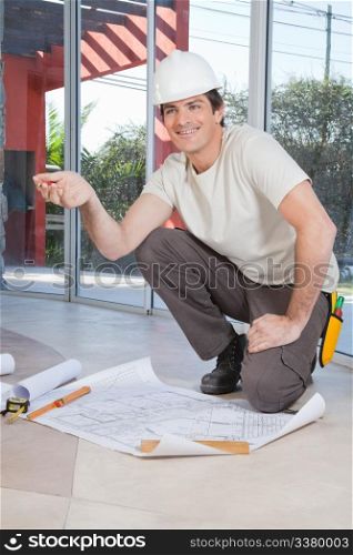 Young construction worker pleased with blueprint