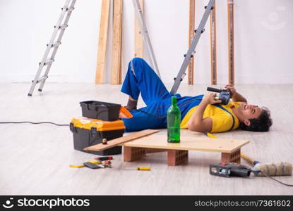 Young contractor drinking in the apartment 