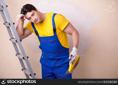 Young contractor employee applying plaster on wall