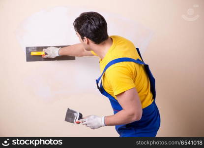 Young contractor employee applying plaster on wall