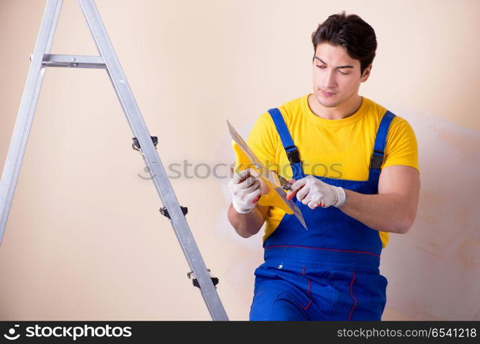 Young contractor employee applying plaster on wall