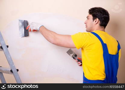 Young contractor employee applying plaster on wall