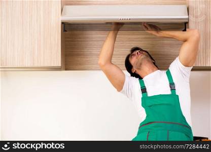 Young contractor repairing air-conditioner in kitchen