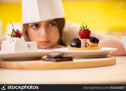 Young cook cooking cakes in the kitchen