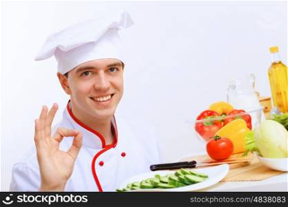 Young cook preparing food with red apron