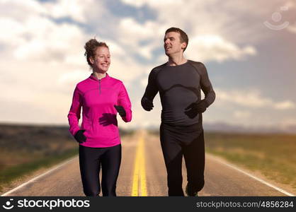 Young couble running down the road with beautiful landscape in background