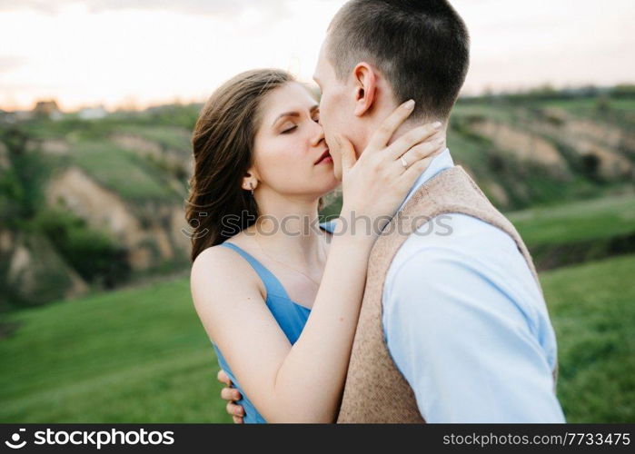 young couple a guy and a girl are walking in the green mountain hills