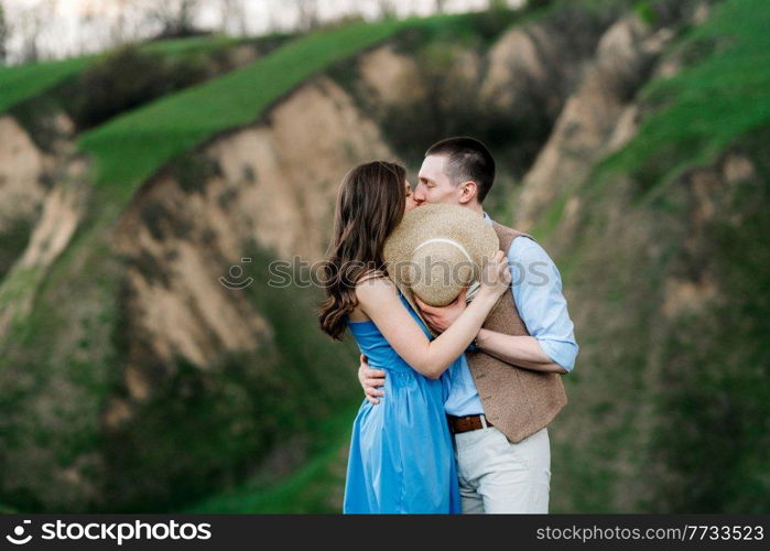 young couple a guy and a girl are walking in the green mountain hills