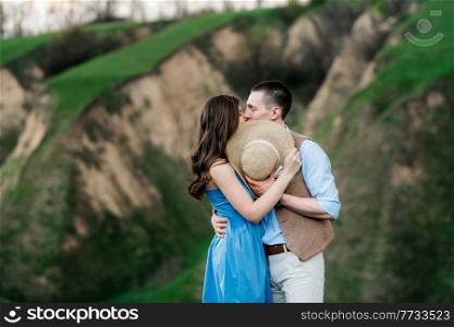 young couple a guy and a girl are walking in the green mountain hills