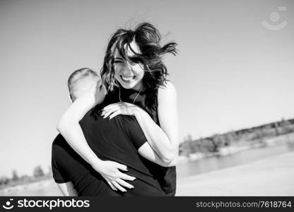 young couple a guy and a girl with joyful emotions in black clothes walk through the snow white desert