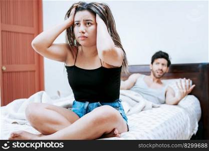 Young couple arguing sitting on the bed. Concept of couple problems in bed. Upset woman with husband sitting on bed, Wife arguing with her husband in bed