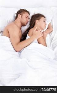 Young couple asleep in bed