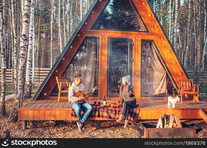 Young couple at autumn warm day on the terrace of their house. Happy family of two on the terrace in autumn