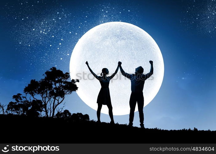 Young couple at date. Silhouettes of young couple against full moon