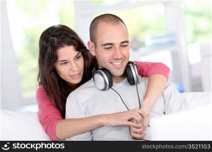 Young couple at home listening to music on internet