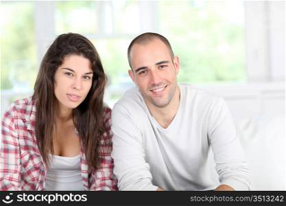 Young couple at home sitting in couch