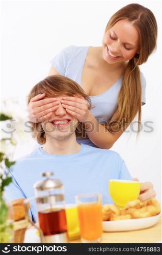 Young couple at home together - closing partner's eyes