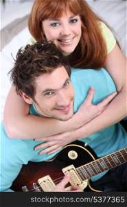 Young couple at home with a guitar