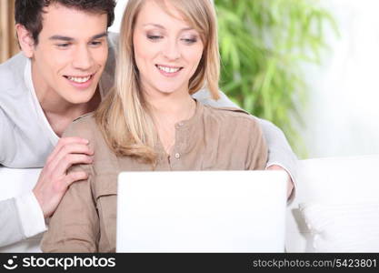 Young couple at home with a laptop