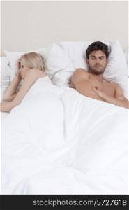 Young couple avoiding each other in bed