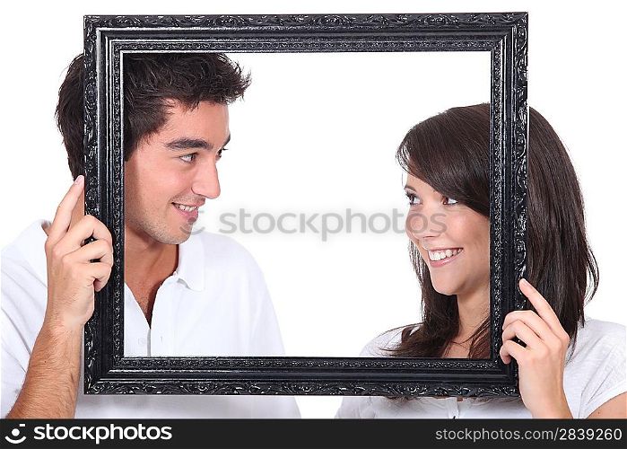Young couple behind photo frame
