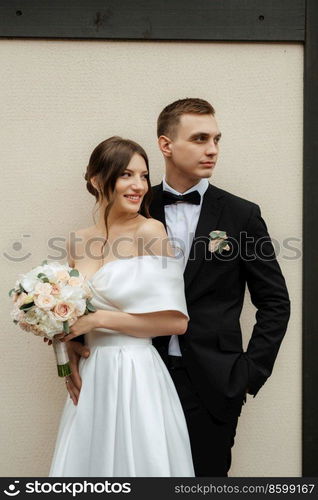 young couple bride and groom in a white short dress walking in the rain