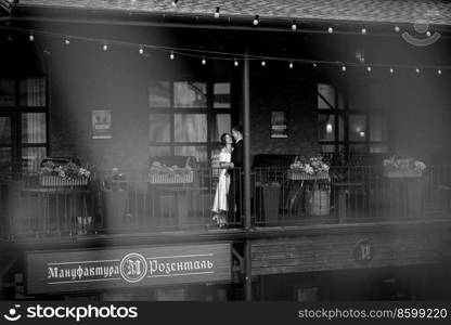 young couple bride and groom in a white short dress walking in the rain