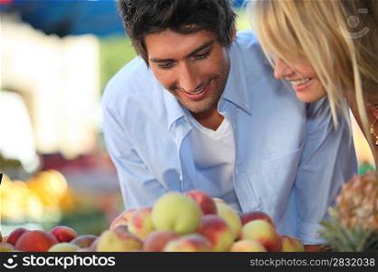Young couple buying fruit at a market