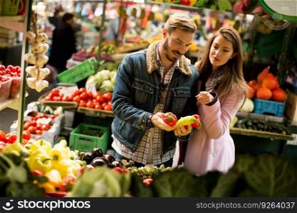 Young couple buying fruits and vegetables on a market
