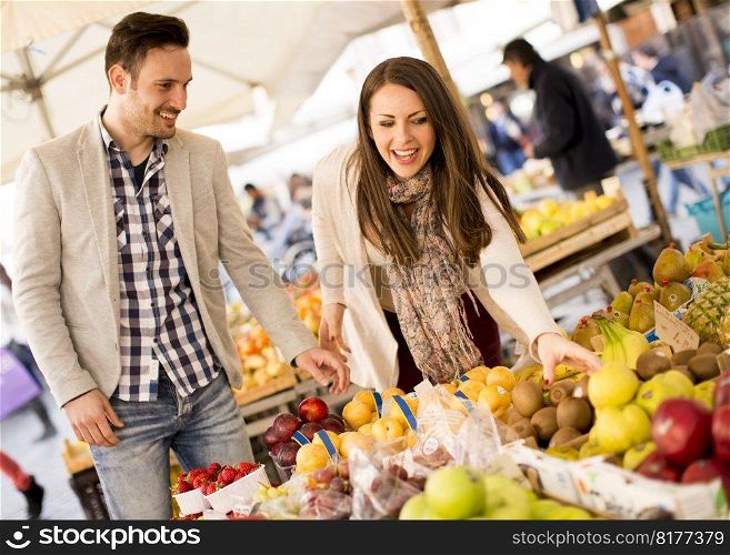 Young couple buying vegetables on a market