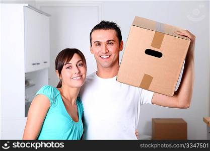 Young couple carrying boxes into new house