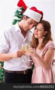 Young couple celebraring christmas with ch&agne