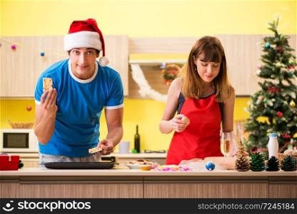 Young couple celebrating Christmas in kitchen 