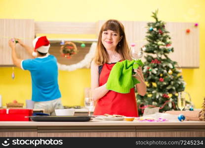 Young couple celebrating Christmas in kitchen 