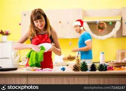 Young couple celebrating Christmas in kitchen 