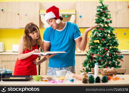 Young couple celebrating Christmas in kitchen 