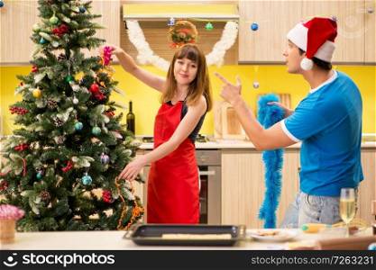 Young couple celebrating Christmas in kitchen . The young couple celebrating christmas in kitchen 