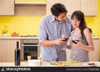 Young couple celebrating wedding anniversary at kitchen 