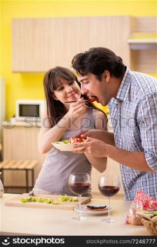Young couple celebrating wedding anniversary at kitchen 
