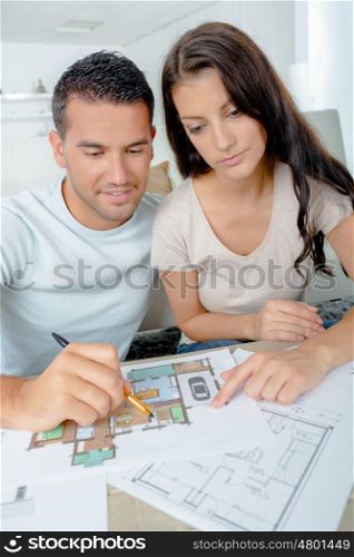 young couple checking architecture plans