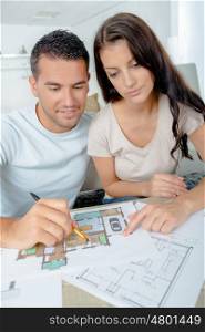young couple checking architecture plans