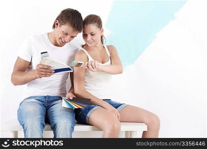 Young couple chooses a color to paint walls