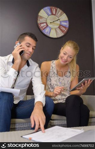 young couple conducting business through the phone