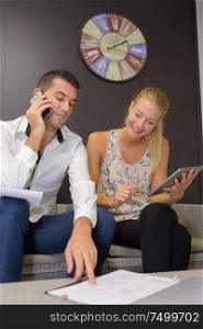 young couple conducting business through the phone
