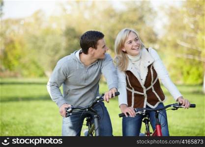 Young couple cycling in a park